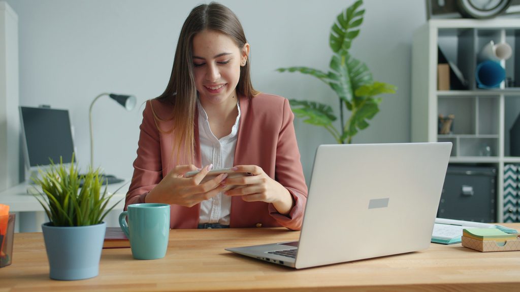 Professional at a desk reviewing job applications on a laptop while preparing for a career change