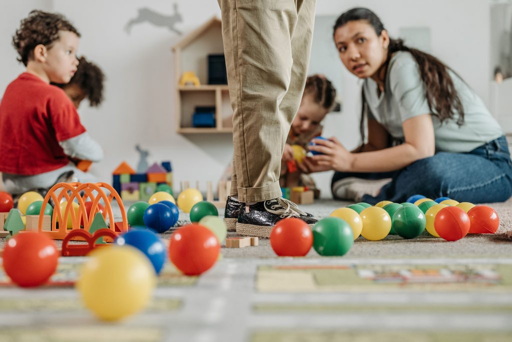 Childcare Costs in the US a woman and kids in a nursery playing